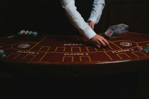 Bàn baccarat trực tiếp với chip cược và dealer đang chia bài