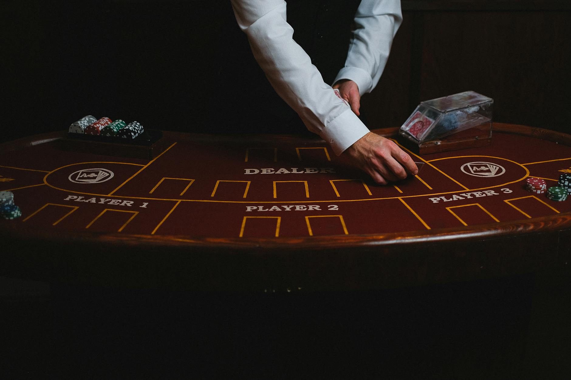 Bàn baccarat trực tiếp với chip cược và dealer đang chia bài